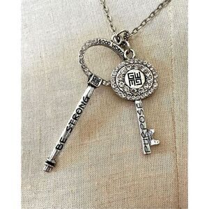 Good Work(s) “ Be Strong” rhinestone key necklace on a silver chain